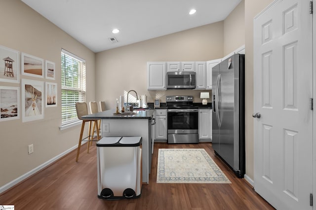 113 Glastonbury Dr, Greer, SC 29651 - kitchen with appliances with stainless steel finishes, a peninsula, dark countertops, white cabinets, and vaulted ceiling