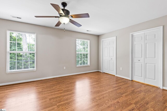 46 Ridgestone Cir, Mauldin, SC 29662 - unfurnished bedroom featuring two closets, multiple windows, wood finished floors, and baseboards