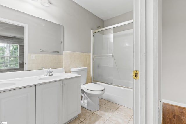 46 Ridgestone Cir, Mauldin, SC 29662 - full bathroom featuring double vanity, tile patterned floors, toilet, combined bath / shower with glass door, and tile walls