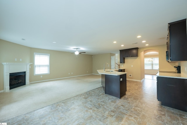 kitchen featuring a ceiling fan, arched walkways, recessed lighting, light countertops, and baseboards