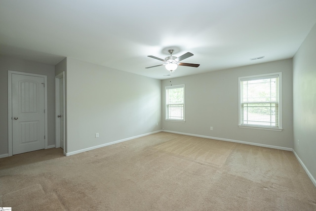 carpeted empty room with baseboards and a ceiling fan