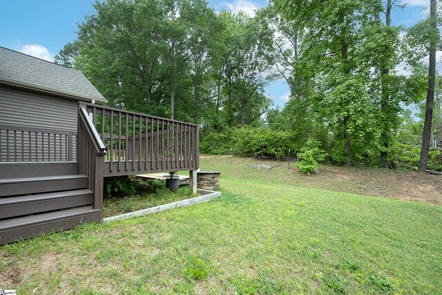 view of grassy yard featuring a wooden deck