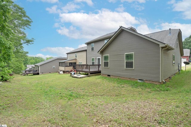 rear view of property with a wooden deck, crawl space, and a yard