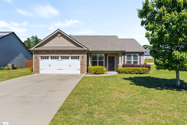 craftsman house featuring an attached garage, a front yard, concrete driveway, central AC unit, and a shingled roof