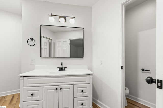 421 Wood Rd, Taylors, SC 29687 - bathroom featuring wood finished floors, vanity, baseboards, and toilet