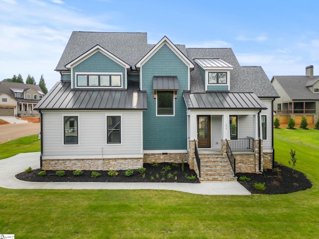 view of front of home featuring a standing seam roof, covered porch, a front lawn, a shingled roof, and metal roof