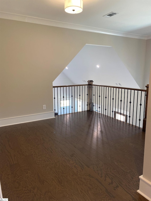 spare room with baseboards, dark wood-type flooring, and crown molding