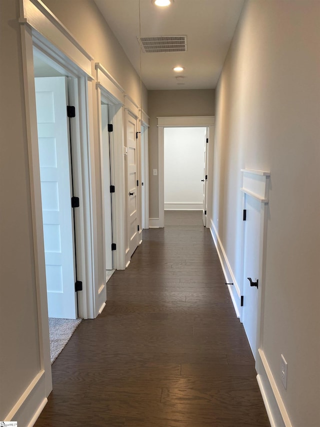 hall featuring dark wood finished floors, recessed lighting, and baseboards