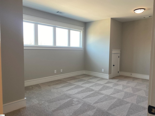 carpeted spare room featuring baseboards