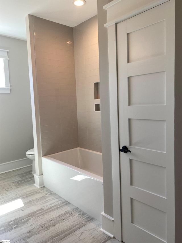 full bath with wood finished floors, toilet, recessed lighting, baseboards, and bathtub / shower combination