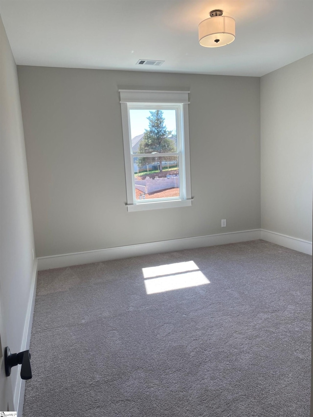 carpeted empty room featuring baseboards