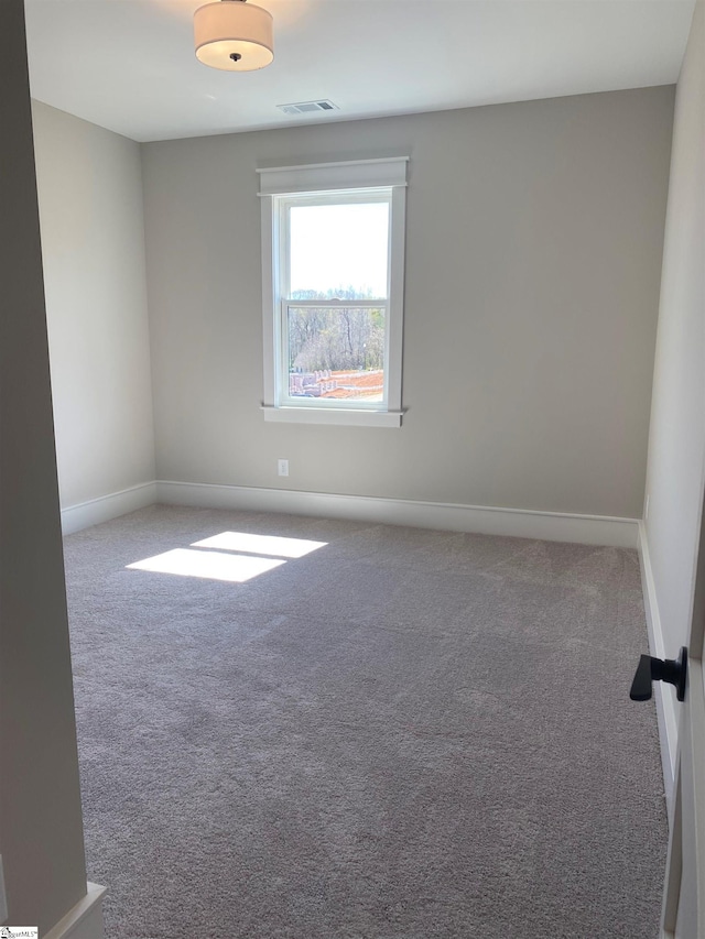 spare room with baseboards and carpet flooring