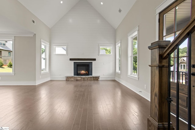 unfurnished living room featuring high vaulted ceiling, a fireplace, dark wood-type flooring, and baseboards