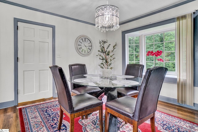 dining room featuring a chandelier, ornamental molding, baseboards, and wood finished floors