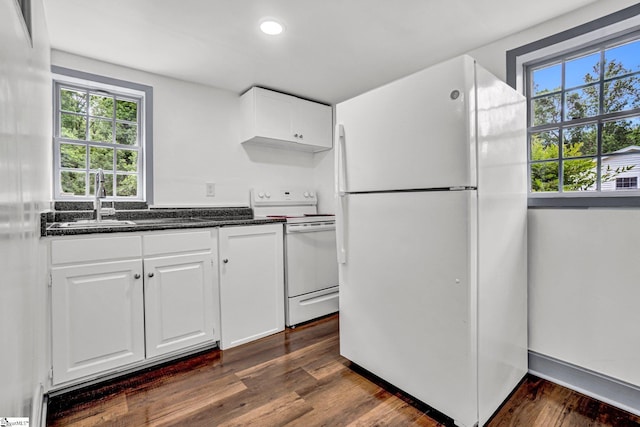 kitchen featuring white appliances, healthy amount of natural light, dark wood-style floors, dark stone countertops, and recessed lighting