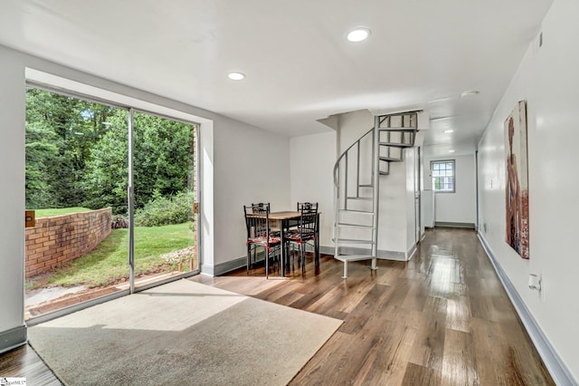 dining space featuring wood finished floors, baseboards, stairway, and recessed lighting