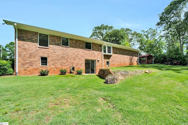 rear view of property featuring a yard and brick siding