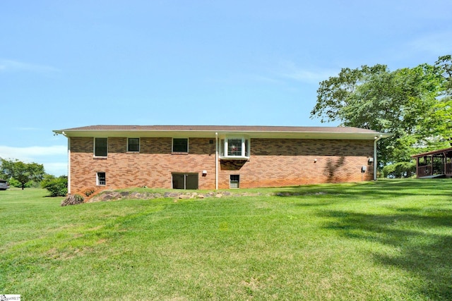 back of house with a yard and brick siding