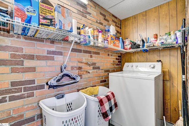 laundry room with washer / dryer, brick wall, and wood walls