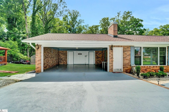 view of front of property featuring brick siding, a chimney, driveway, and a carport
