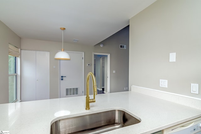 kitchen with a sink, hanging light fixtures, dishwasher, and light stone counters