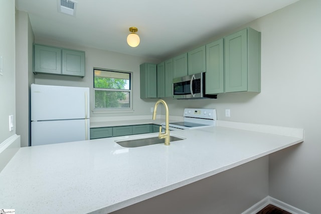 kitchen with white appliances, green cabinets, and a peninsula