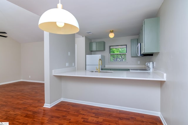 kitchen with stove, freestanding refrigerator, dark wood-type flooring, and a peninsula