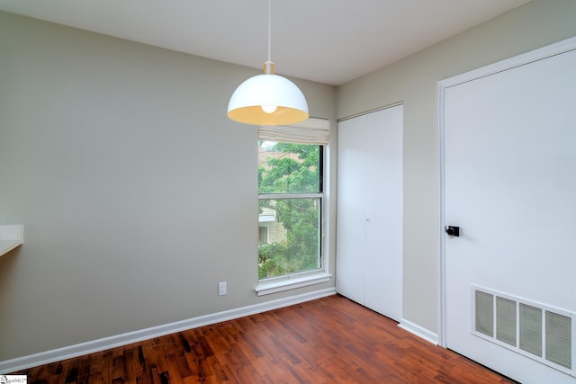 empty room with dark wood-style flooring and baseboards