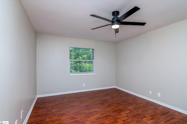 empty room with ceiling fan, wood finished floors, and baseboards