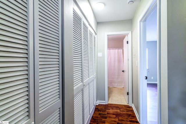 hallway with dark wood-style floors and baseboards
