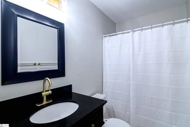 bathroom featuring toilet, vanity, and a shower with curtain