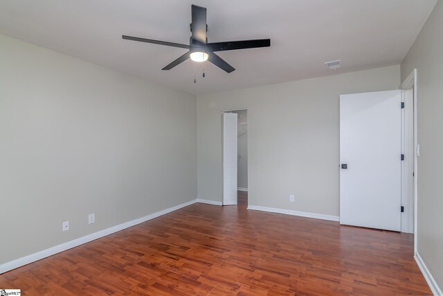 empty room featuring a ceiling fan, wood finished floors, and baseboards