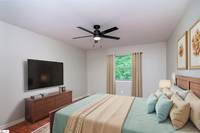 bedroom featuring wood finished floors, baseboards, and ceiling fan