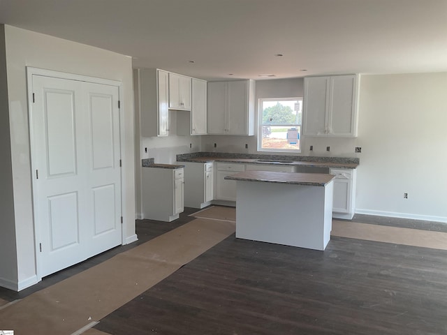 3 Wenck Cir, Fountain Inn, SC 29644 - kitchen with dark wood finished floors, a center island, baseboards, white cabinets, and dark countertops