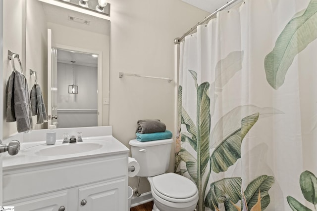 bathroom featuring toilet, vanity, and curtained shower
