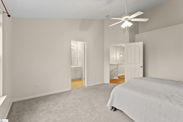 carpeted bedroom with baseboards, connected bathroom, high vaulted ceiling, and a ceiling fan