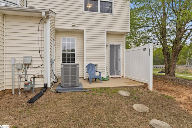 back of property with central AC unit and a patio area