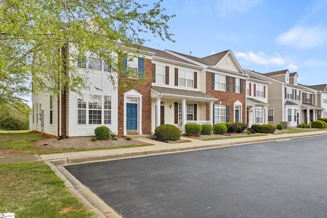 multi unit property with brick siding and a residential view