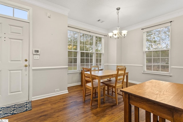 dining space with wood finished floors, a chandelier, plenty of natural light, and ornamental molding