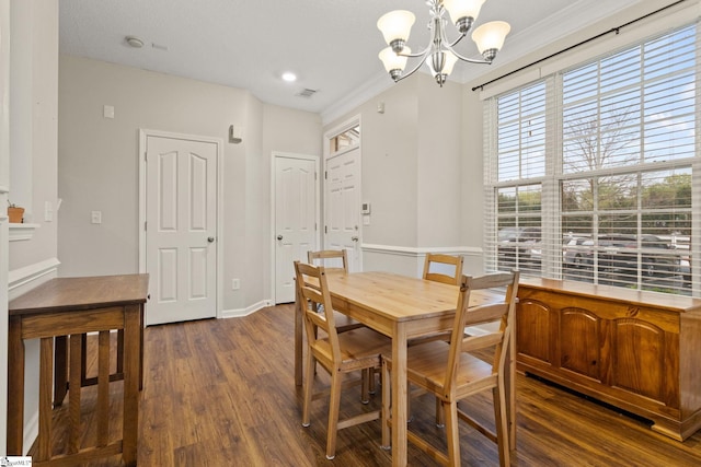 dining room with a chandelier, dark wood-style floors, crown molding, and baseboards