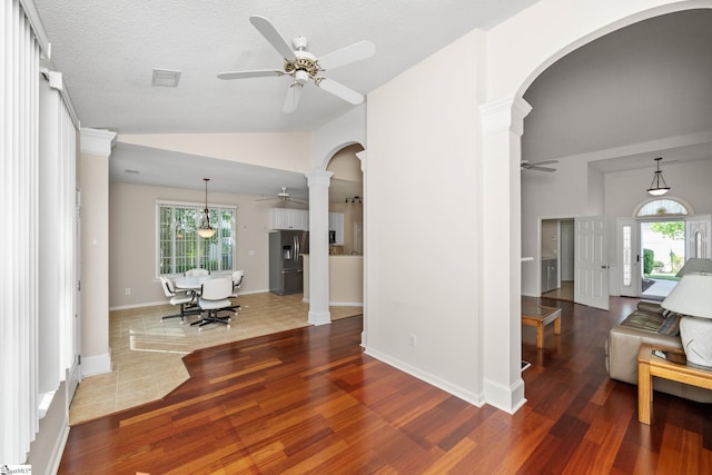 325 Waterton Way, Simpsonville, SC 29680 - living room featuring ceiling fan, arched walkways, decorative columns, wood finished floors, and vaulted ceiling