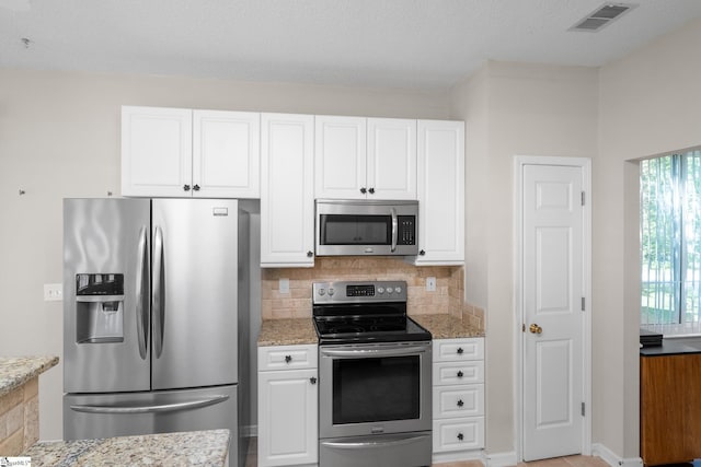 325 Waterton Way, Simpsonville, SC 29680 - kitchen featuring appliances with stainless steel finishes, white cabinets, light stone counters, and tasteful backsplash
