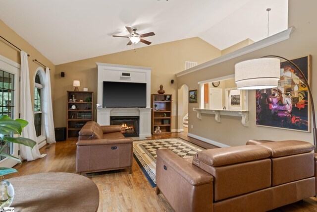 6 Pebble Stone Ln, Taylors, SC 29687 - living room with a ceiling fan, wood finished floors, lofted ceiling, arched walkways, and a warm lit fireplace