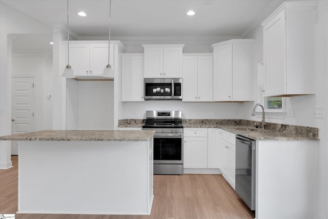 107A W Stewart St, Pelzer, SC 29669 - kitchen featuring appliances with stainless steel finishes, a sink, light wood-style floors, white cabinets, and ornamental molding