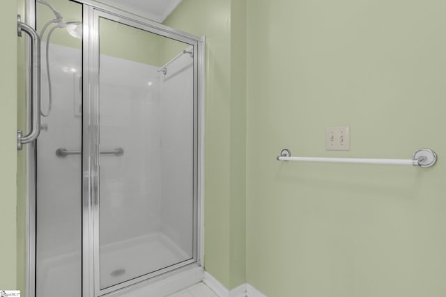 bathroom featuring a stall shower and baseboards