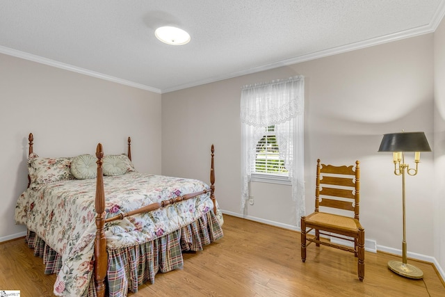 bedroom with crown molding, wood finished floors, and baseboards