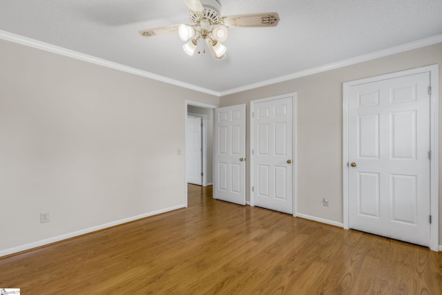 unfurnished bedroom with wood finished floors, baseboards, crown molding, and ceiling fan