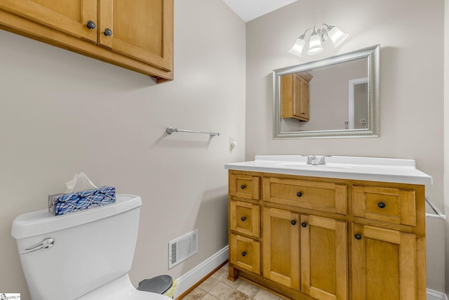 half bathroom with baseboards, toilet, and vanity
