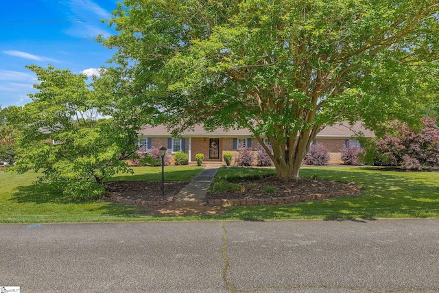 view of front of property featuring a front yard and brick siding