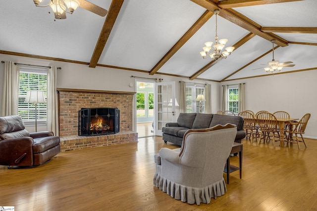 living room with a ceiling fan, plenty of natural light, wood finished floors, and a fireplace